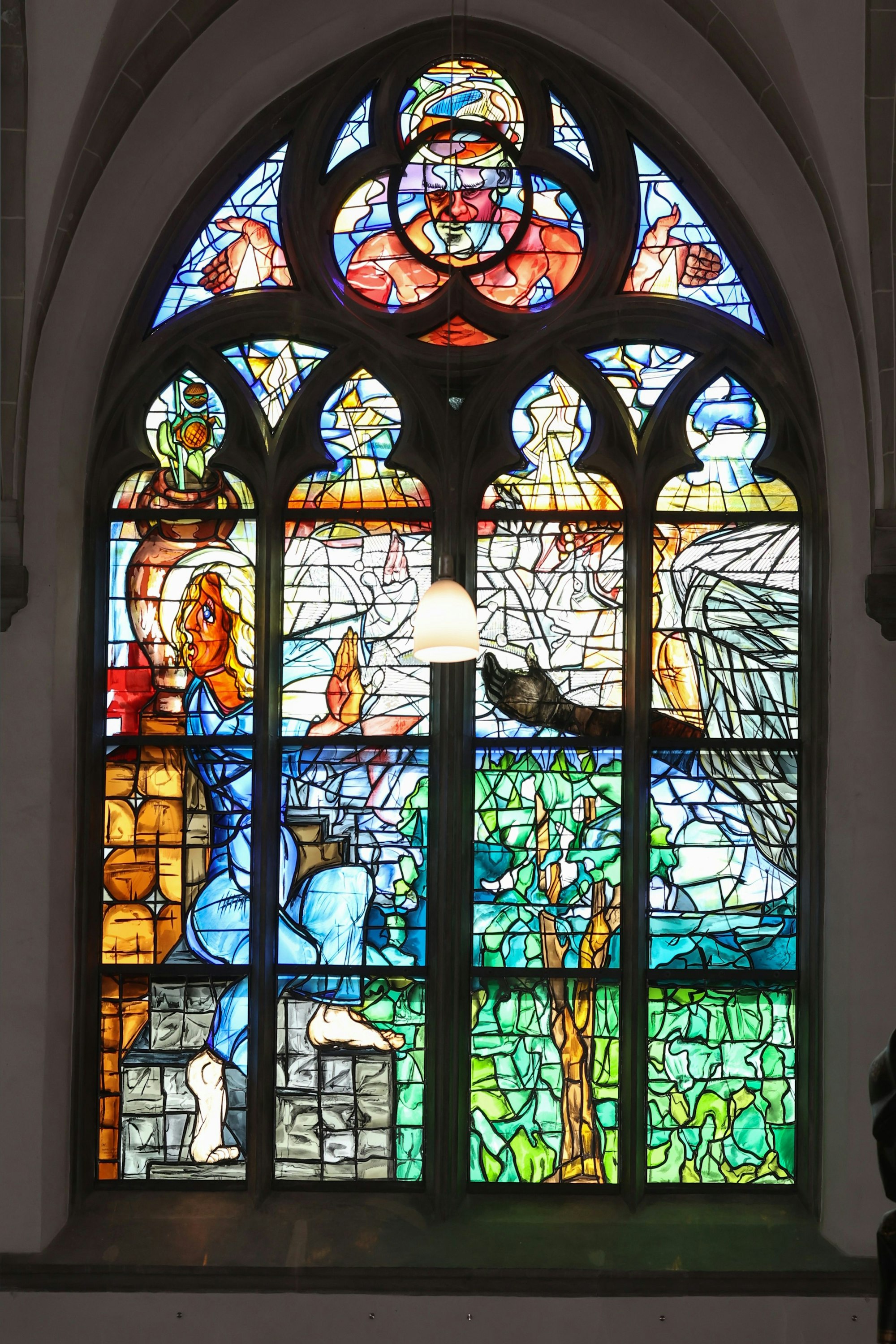 Eine bunte Glasmalerei zeigt, wie ein Engel der Jungfrau Maria die frohe Botschaft bringt.