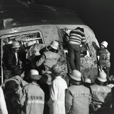 Auf dem Foto ist zu sehen, wie Feuerwehrleute verletzte Passagiere bergen.