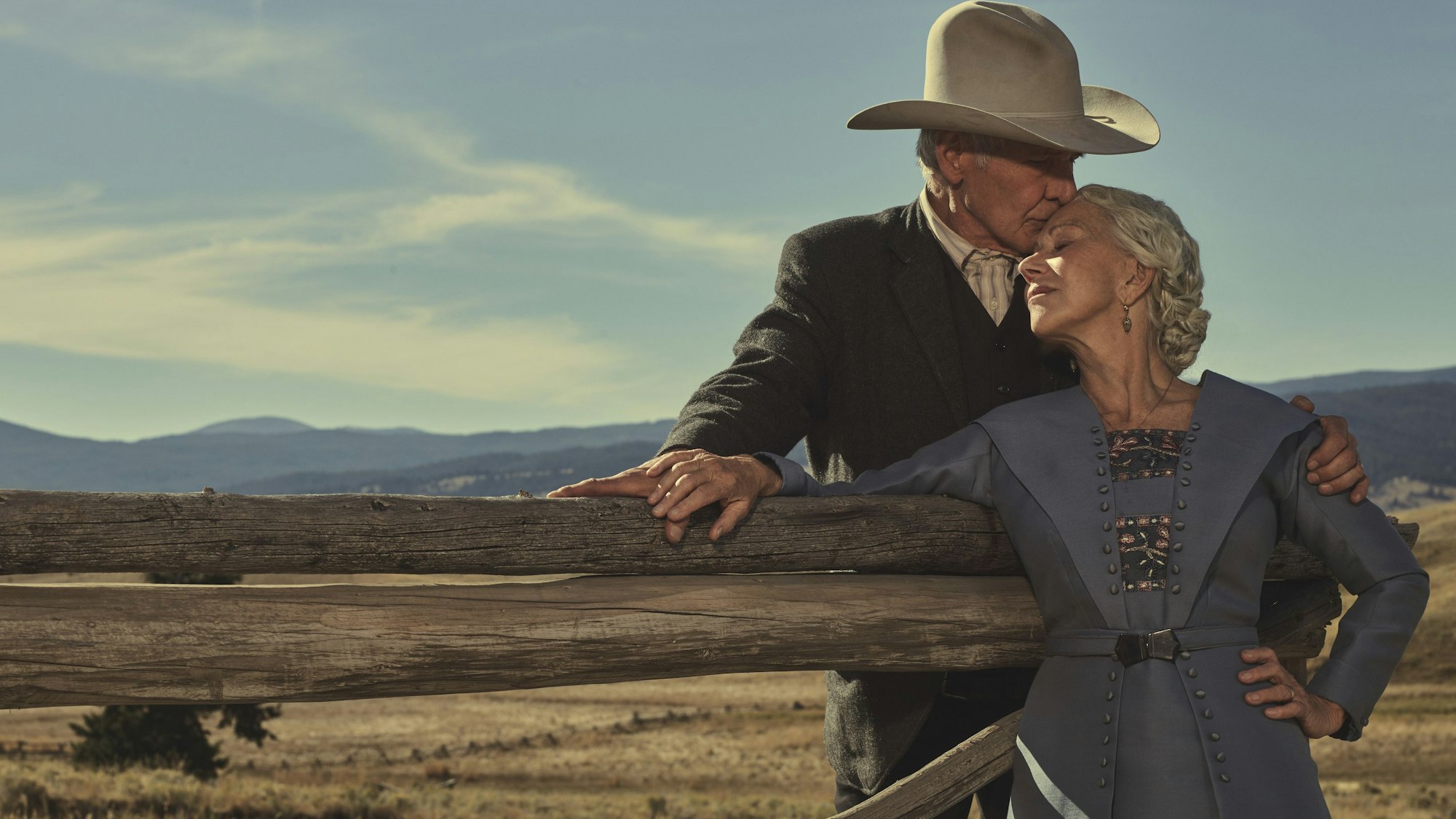 Ein Mann mit Cowboyhut küsst seine Frau.