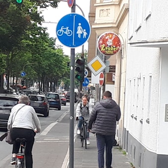 Fahrradfahrer und Fußgänger, die sich auf einem engen Rad- und Fußweg entgegen kommen,
