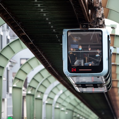 Eine Schwebebahn fährt über der Kaiserstraße in Vohwinkel entlang.