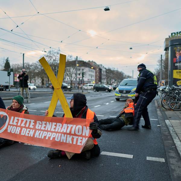 Aktivisten der „Letzten Generation“ kleben sich auf der Fahrbahn fest – Polizisten tragen Aktivisten von der Fahrbahn.