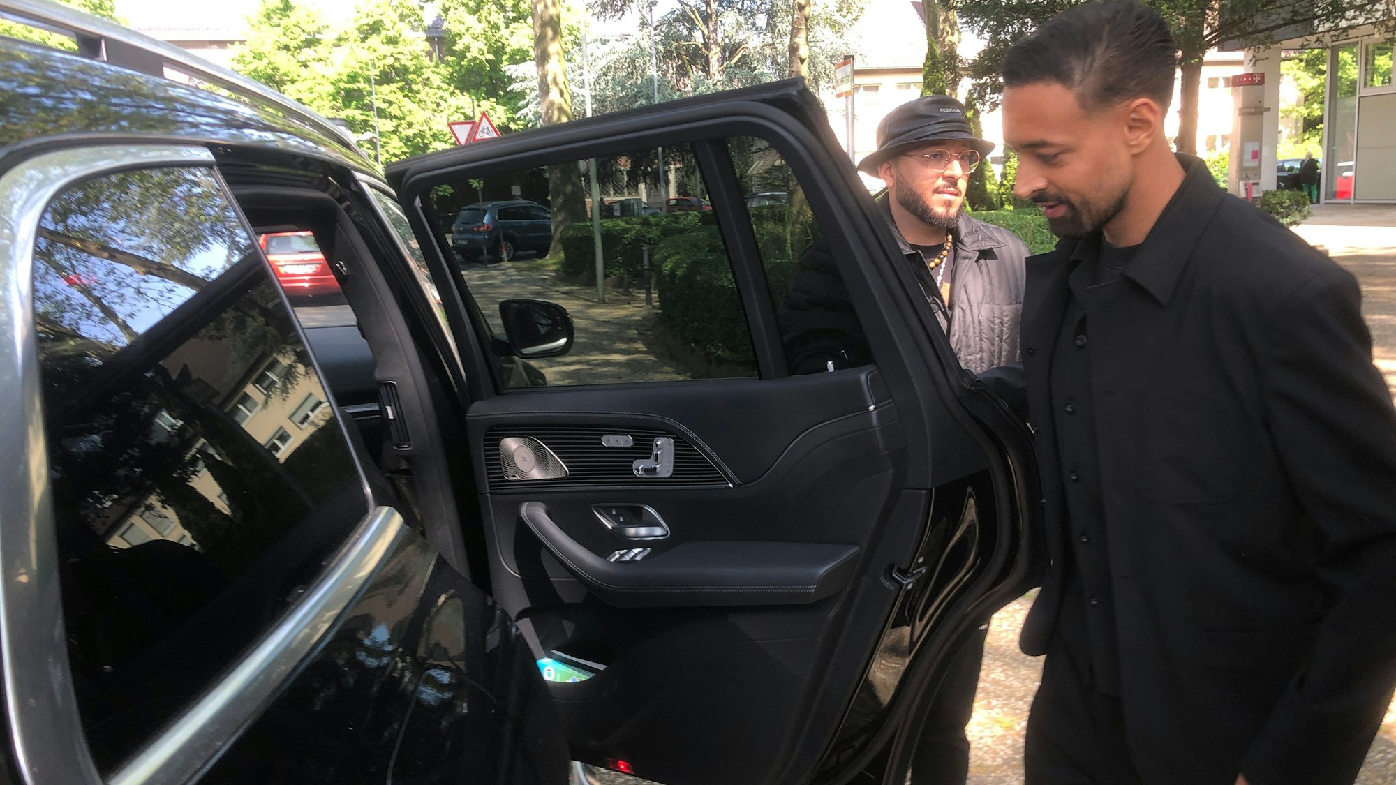 Karim Bellarabi steigt in sein Auto, hinten der Chauffeur.