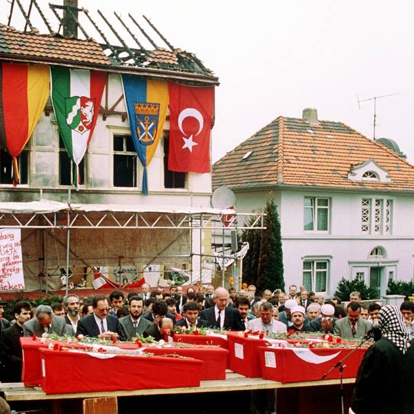 Das Foto zeigt die Särge von fünf Türkinnen vor dem ausgebrannten Haus in Solingen bei einer Trauerfeier.