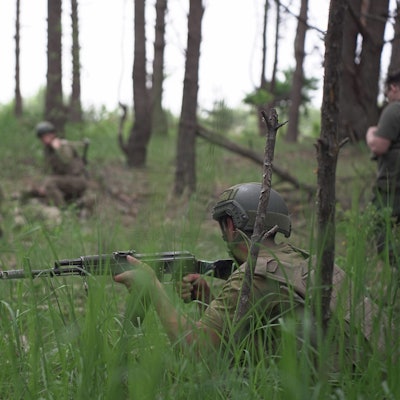 25.05.2023, Ukraine: Ukrainische Soldaten nehmen an einer Militärübung in einem Stützpunkt außerhalb von Kiew teil. Soldaten der regulären Infanterie der ukrainischen Streitkräfte erhalten eine intensive medizinische Ausbildung durch Freiwillige der Prytula-Stiftung. Die Ausbilder der Stiftung werden von Experten in der westlichen medizinischen Ausbildung nach NATO-Vorbild geschult. Die Soldaten auf dem großen Militärstützpunkt simulieren die Bedingungen an der Front, leben im Wald und heben über lange Zeiträume Gräben aus.