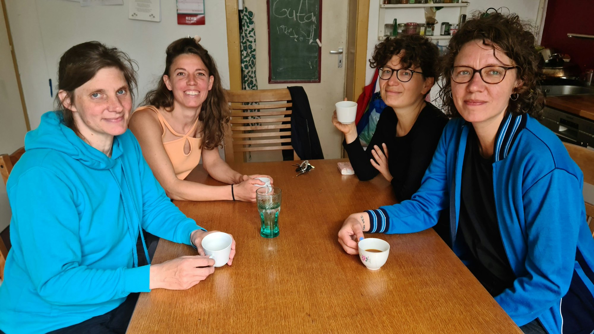 Vier junge Frauen sitzen um einen Tisch herum.