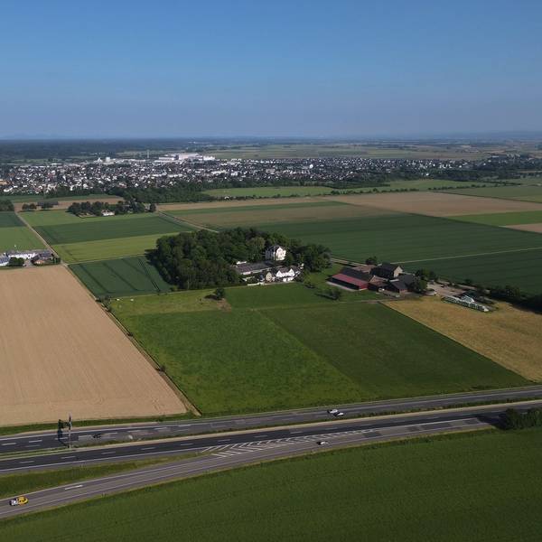 Im Bereich von Gut Neuheim, an der A1, wird auf einer Fläche von 6,3 Hektar ein Solarpark entstehen. Die Luftaufnahme zeigt das Areal, im Hintergrund ist Weilerswist zu erkennen.