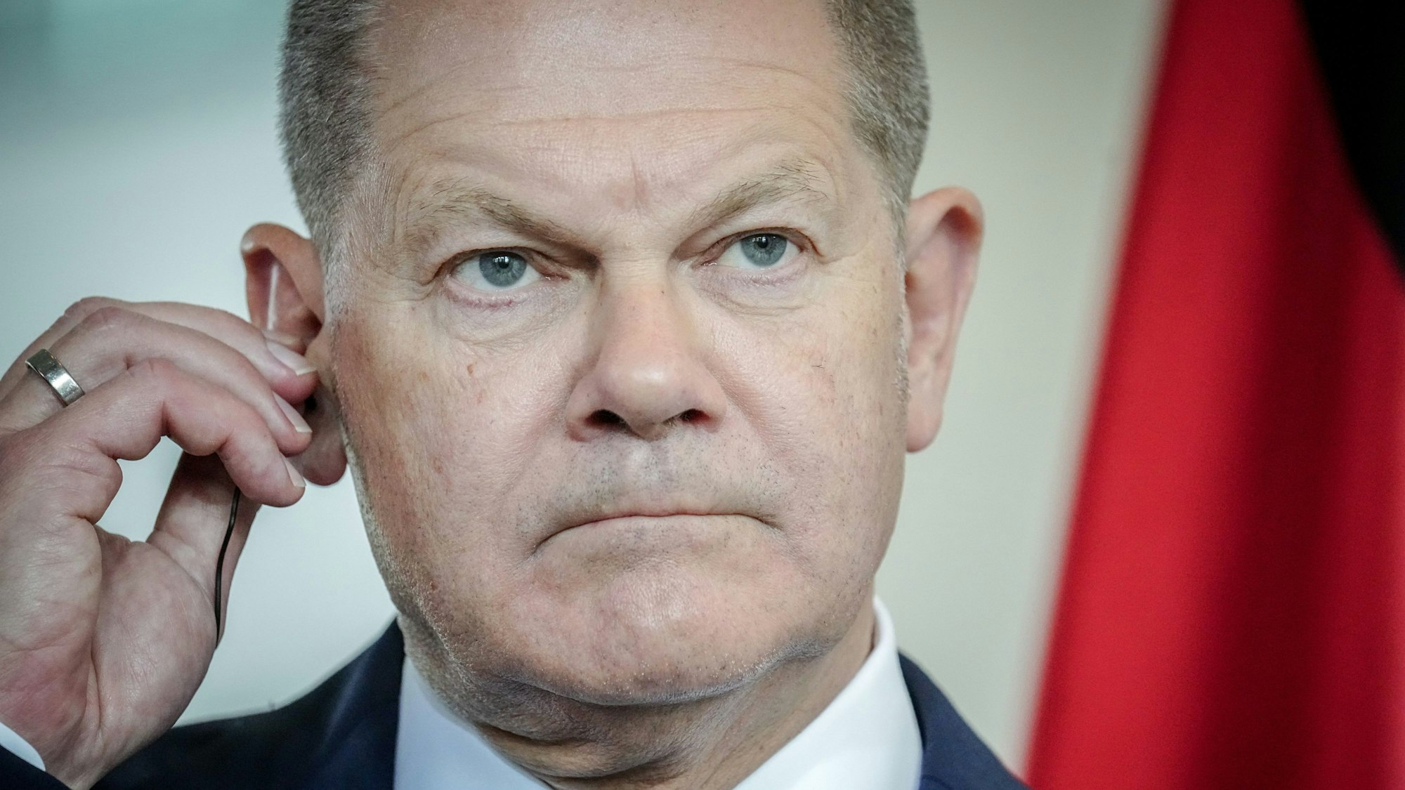 Bundeskanzler Olaf Scholz (SPD) guckt grimmig in die Kamera. Am Flughafen in Frankfurt ist es zu einer Sicherheitspanne um den Kanzler gekommen.