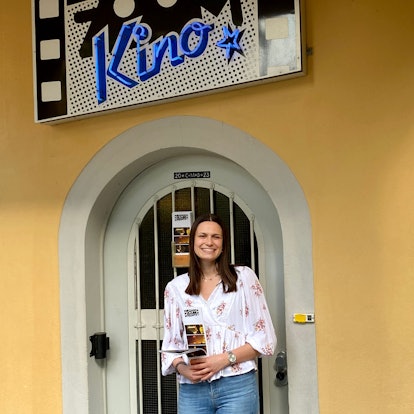 Julia Liebig steht vor dem Eingang des Brühler Zoom-Kinos. Sie hält ein Programm in den Händen.