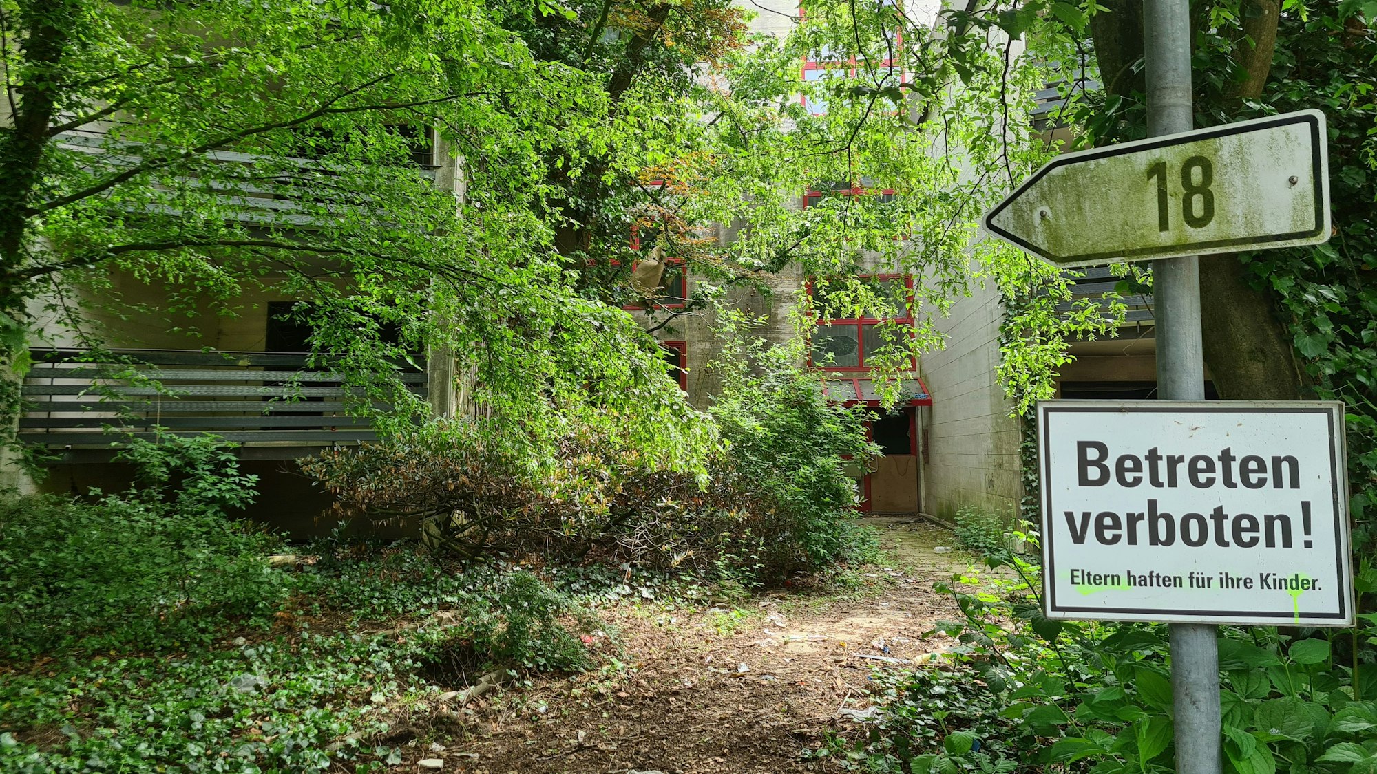 Das Bild zeigt den Wohnblock 18 im Wohnpark. Im Vordergrund ist ein "Betreten verboten" Schild zu sehen.
