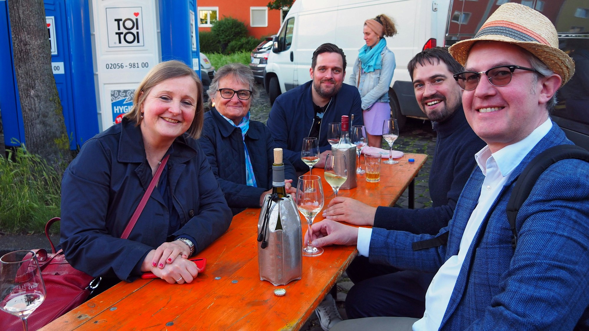 Frauen und Männer sitzen an einem Biertisch.