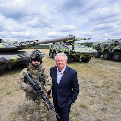 Der Rheinmetall-Vorstandsvorsitzende Armin Papperger (r) und ein Soldat stehen vor einem Kampfpanzer Panther KF51 (l) des Rüstungskonzerns Rheinmetall bei einer Führung durch das Rheinmetall-Werk Unterlüß.