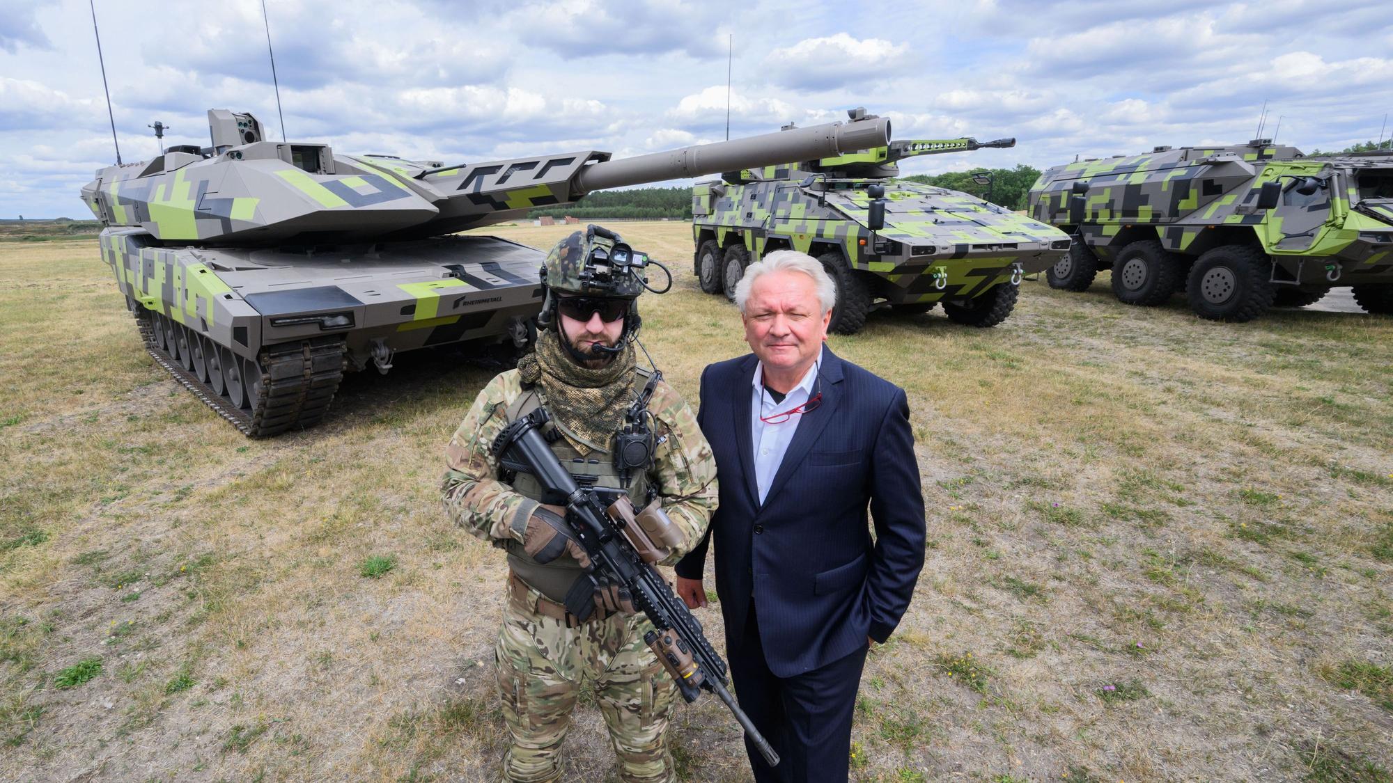 Der Rheinmetall-Vorstandsvorsitzende Armin Papperger (r) und ein Soldat stehen vor einem Kampfpanzer Panther KF51 (l) des Rüstungskonzerns Rheinmetall bei einer Führung durch das Rheinmetall-Werk Unterlüß.