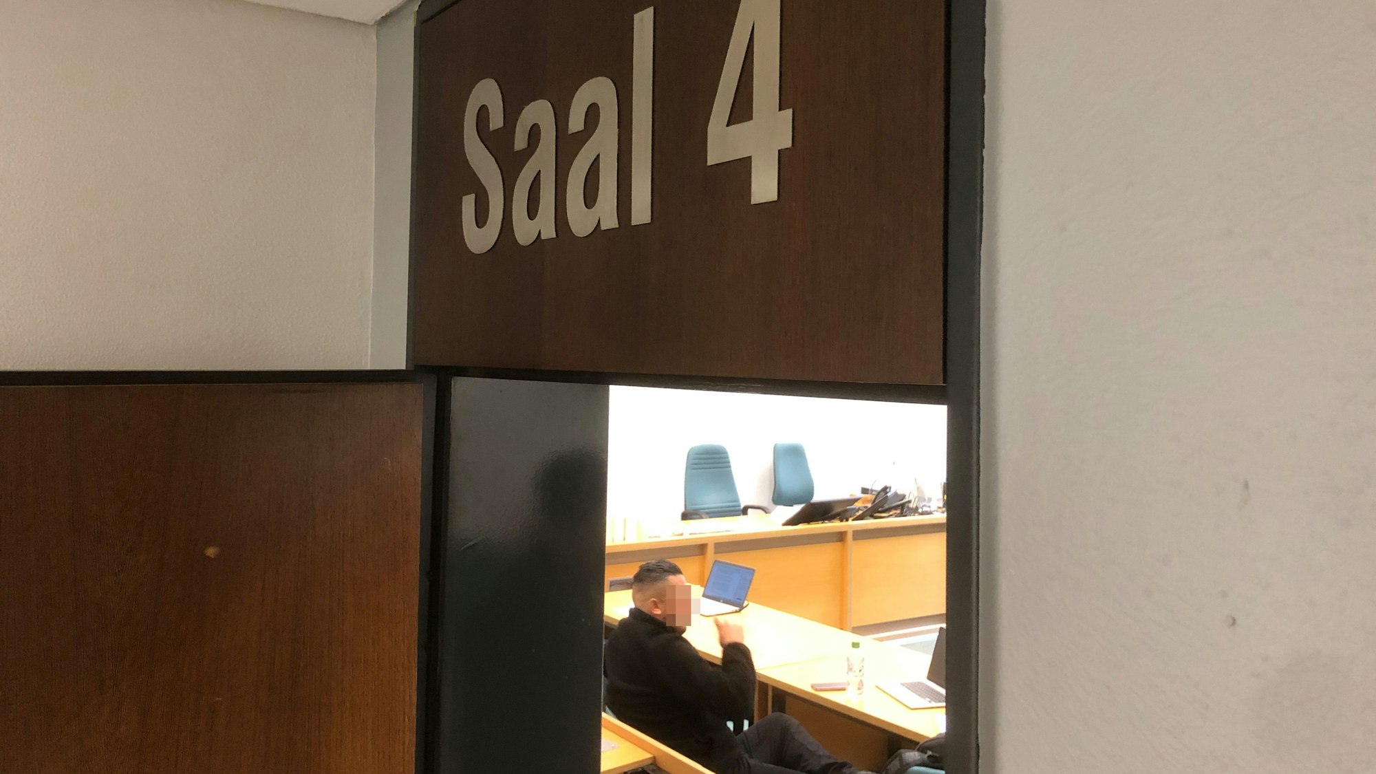Ein Mann sitzt in einem Saal des Amtsgerichts Leverkusen.