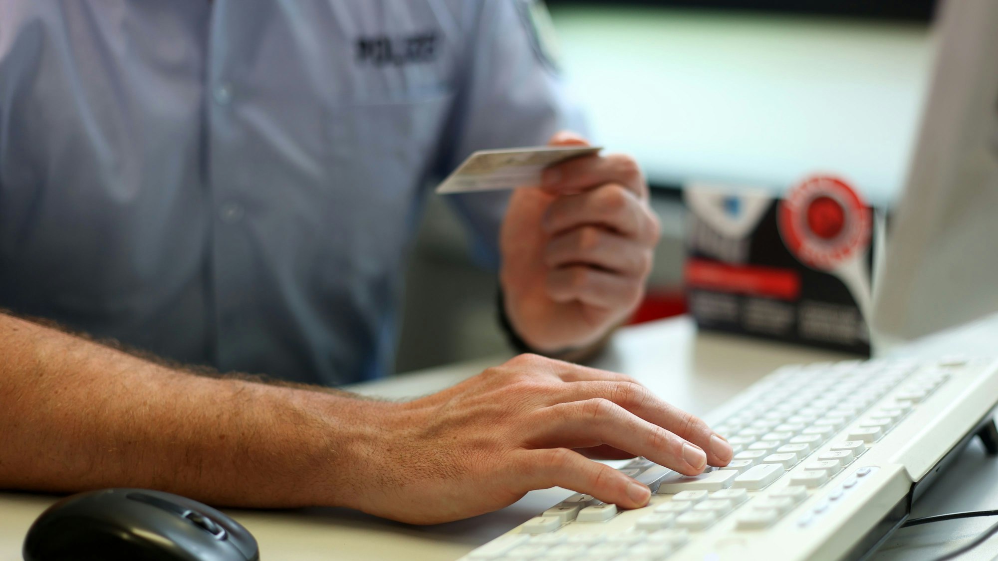 Oberkommissar Benjamin Sepanski gibt Name und Geburtsdatum auf dem Ausweis in den Polizeicomputer ein.