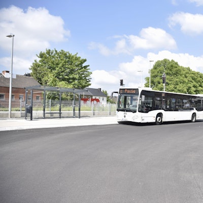 Das Bild zeigt den neuen Zülpicher Busbahnhof. Ein weißer Bus steht an einer Haltestelle.
