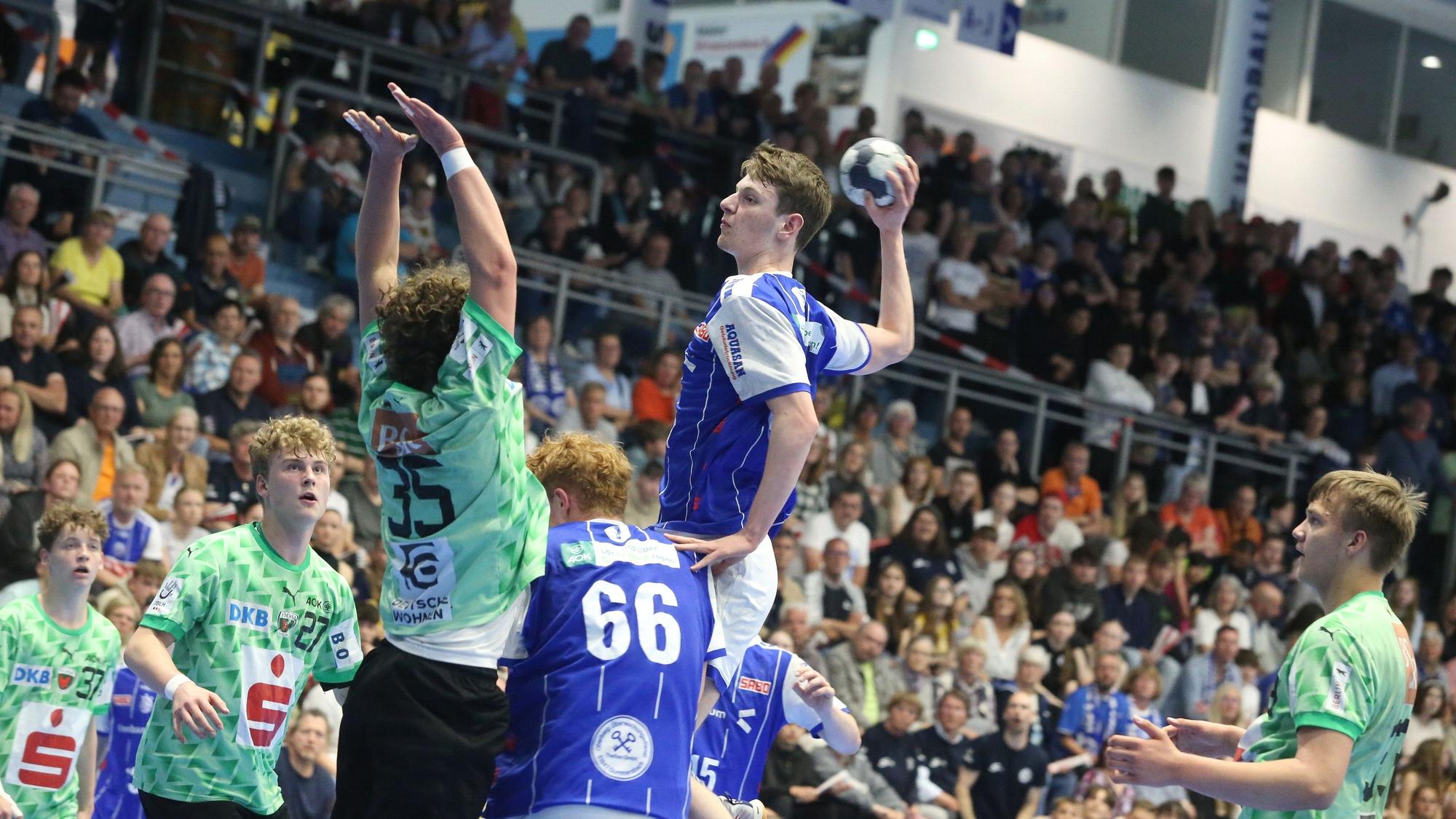 Ein Gummersbacher U17-Handballer hebt vor der gegnerischen Abwehr zum Sprungwurf ab.