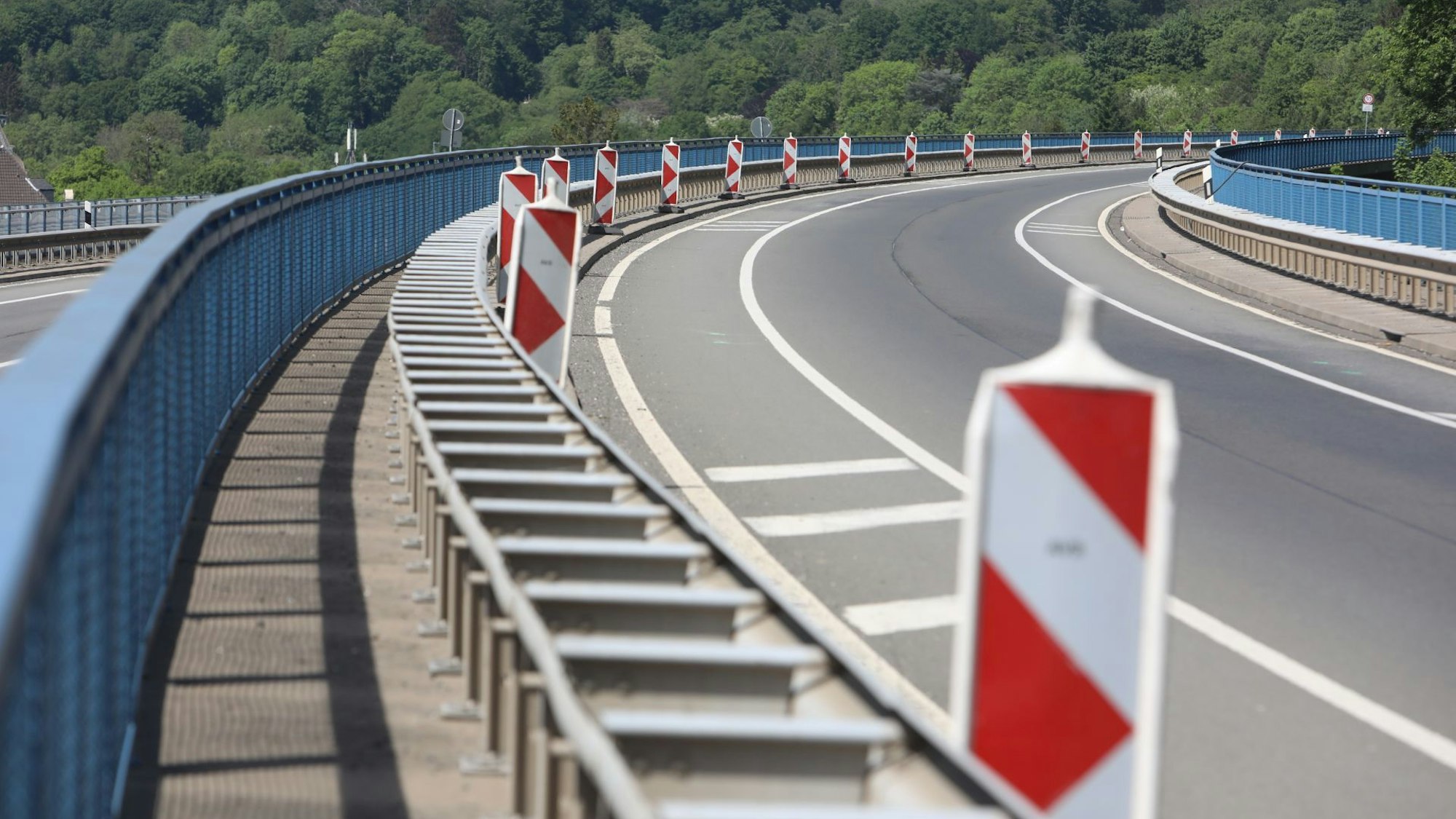 Absperrbaken stehen am Rand der Bundesstraße 42, auf der nicht ein einziges Auto fährt. Die Drachenbrücke mit ihren blauen Geländern wird erneut gesperrt.