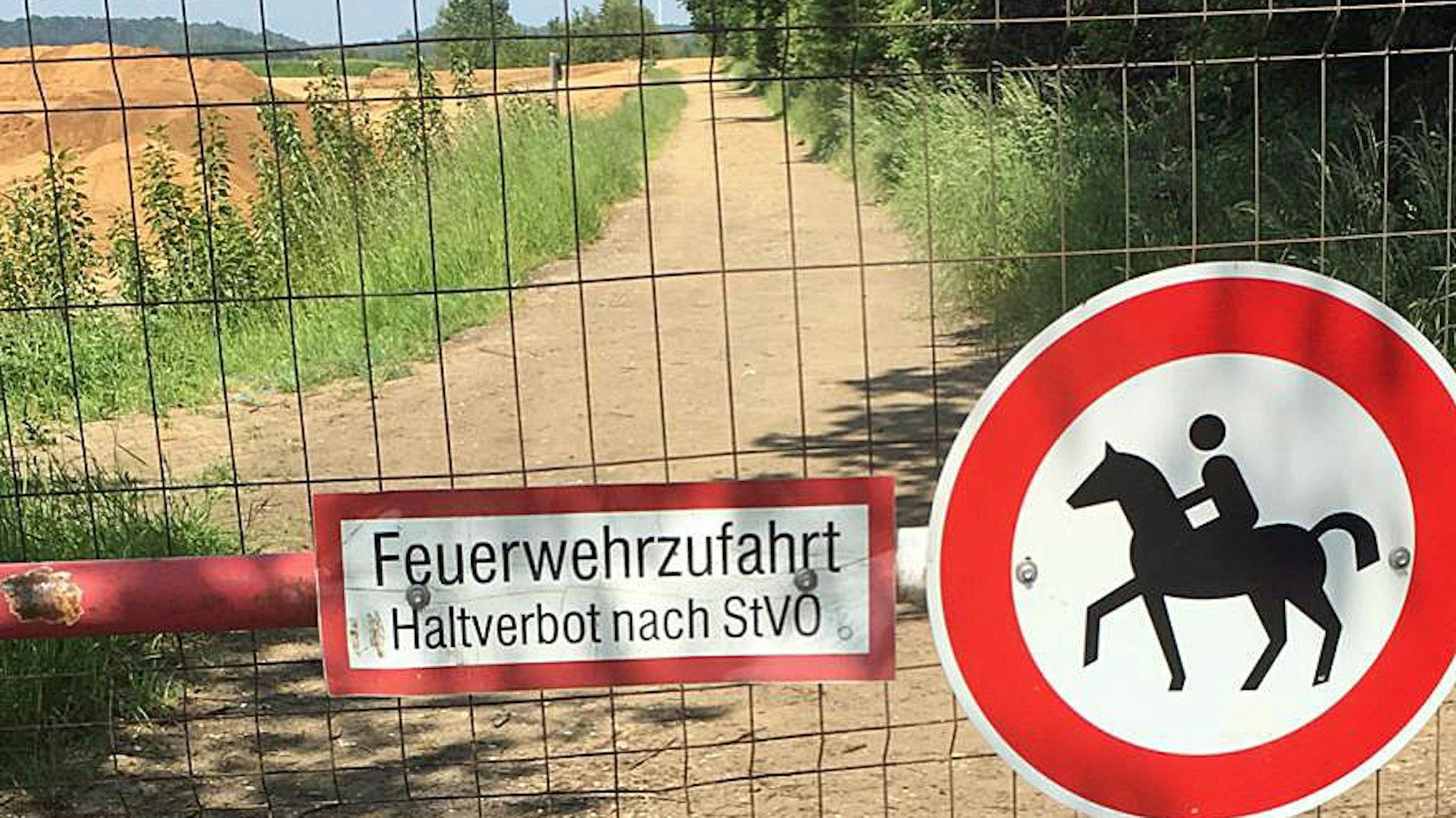Auf dem Foto ist der durch einen Gitterzaun gesperrte Wanderweg zu sehen.