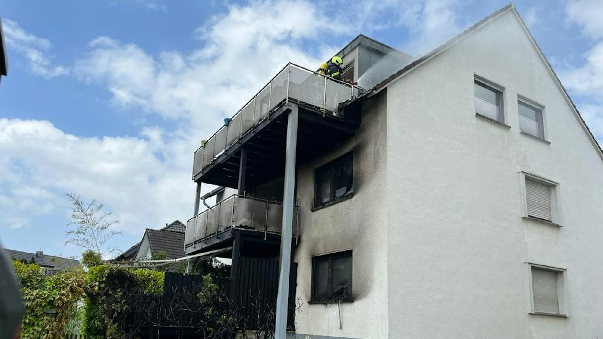 Feuerwehrleute löschen den Brand eines Wohnhauses.