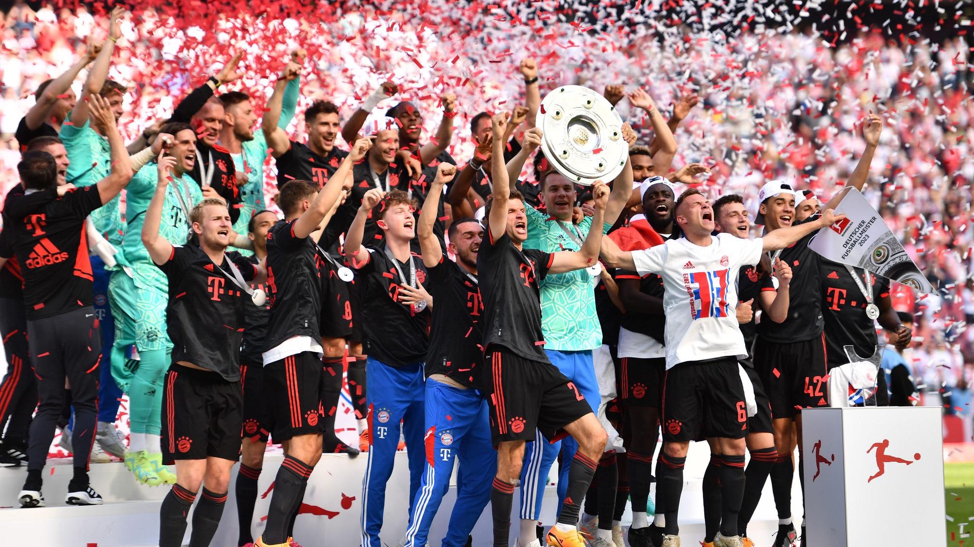 Bayerns Torhüter Manuel Neuer (Mitte r) hält die Meisterschale hoch während seine Teamkollegen nach dem Gewinn der 33. deutschen Meisterschaft jubeln.