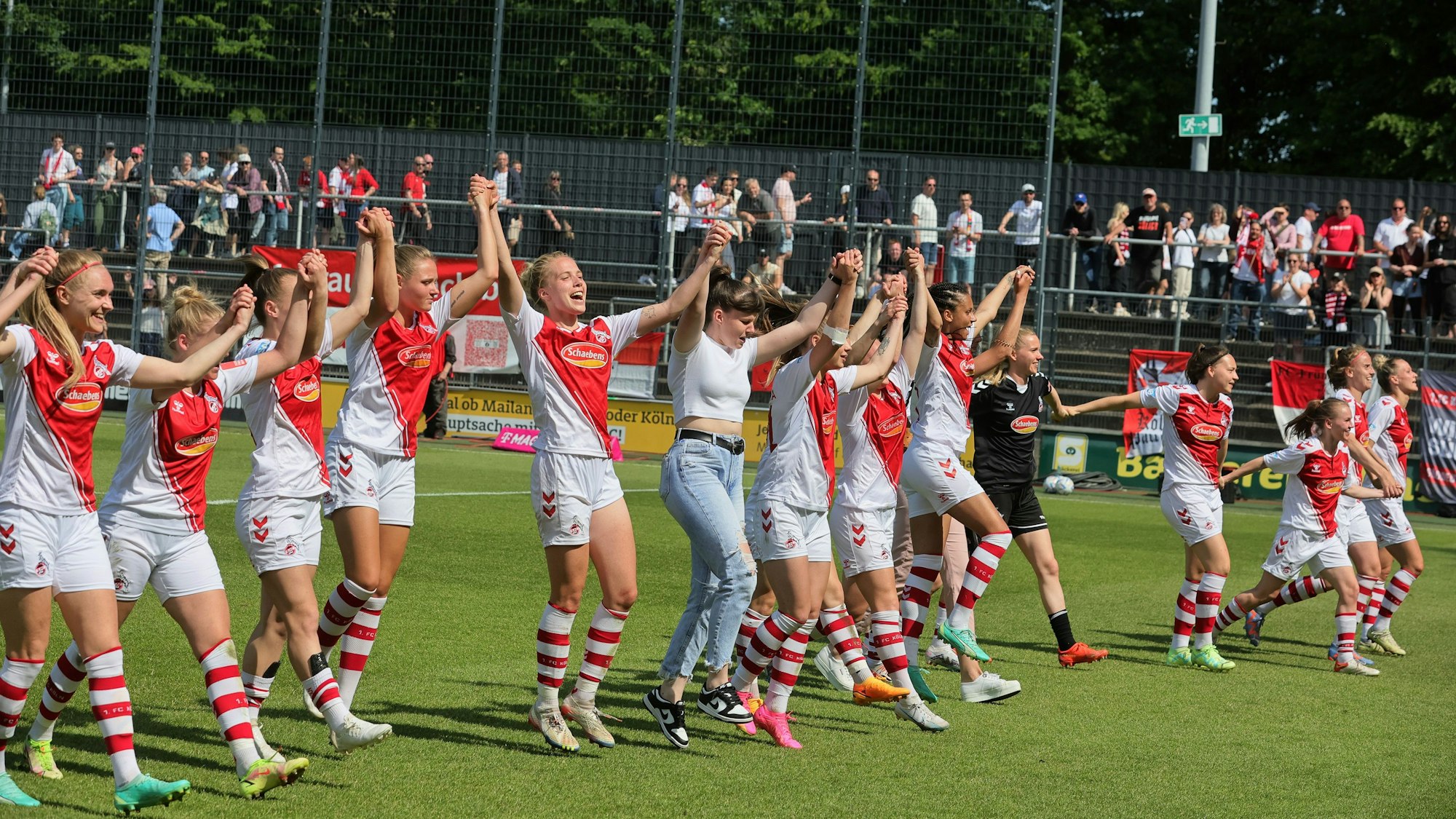 Mit hochgestreckten Armen jubeln die Spielerinnen des 1. FC Köln – im letzten Spiel der Saison haben sie den Klassenerhalt gesichert.