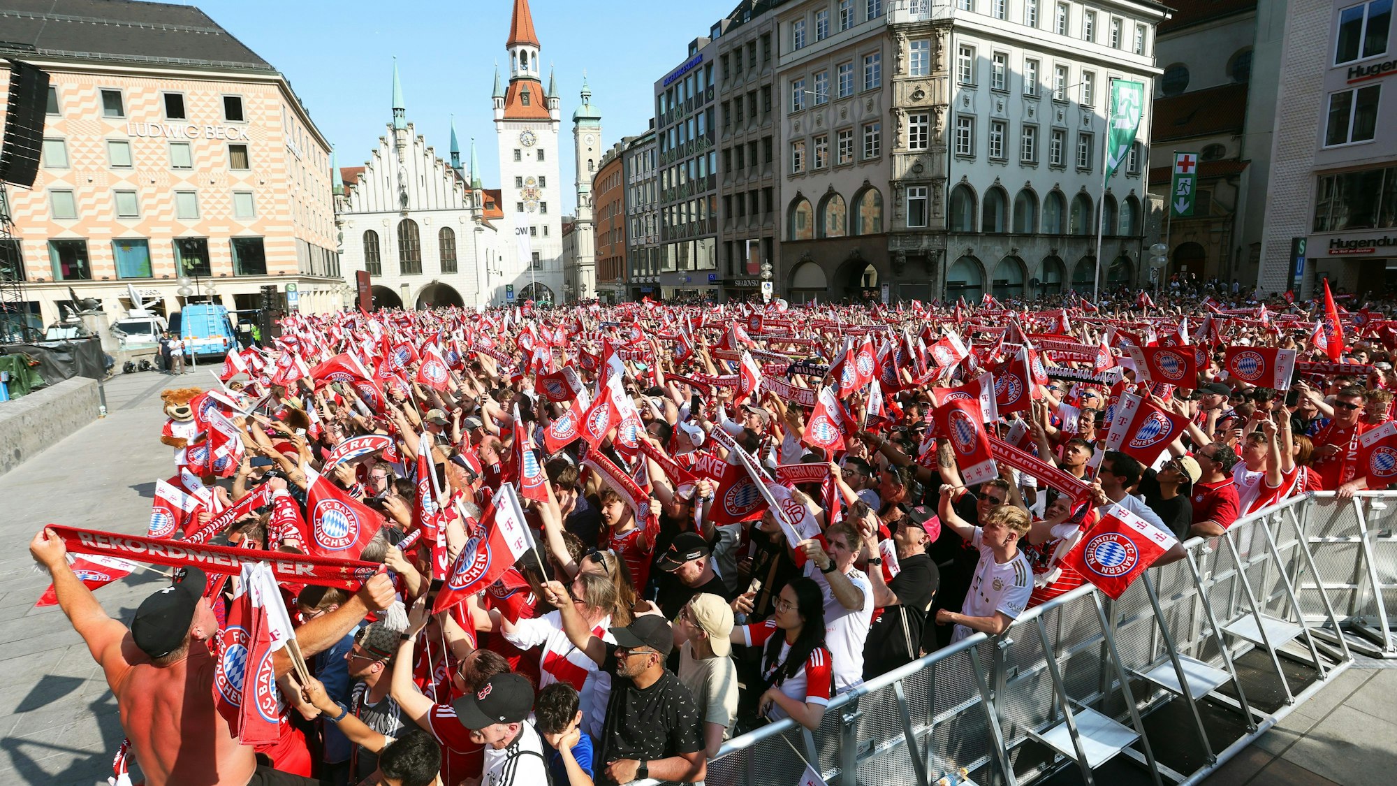 Fans des FC Bayern München warten auf dem Marienplatz auf die Mannschaften.