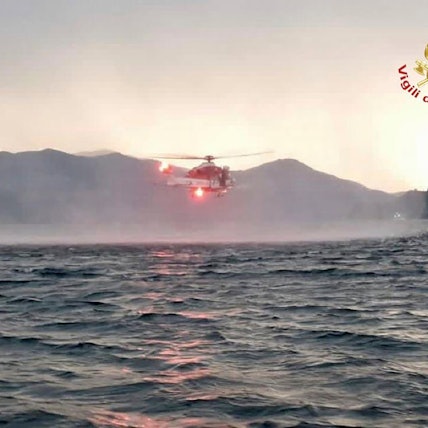 Dieses von der italienischen Feuerwehr veröffentlichten Bild zeigt einen Hubschrauber bei der Suche nach Vermissten, nachdem ein Touristen-Boot in einem Sturm auf dem italienischen Lago Maggiore gekentert ist.