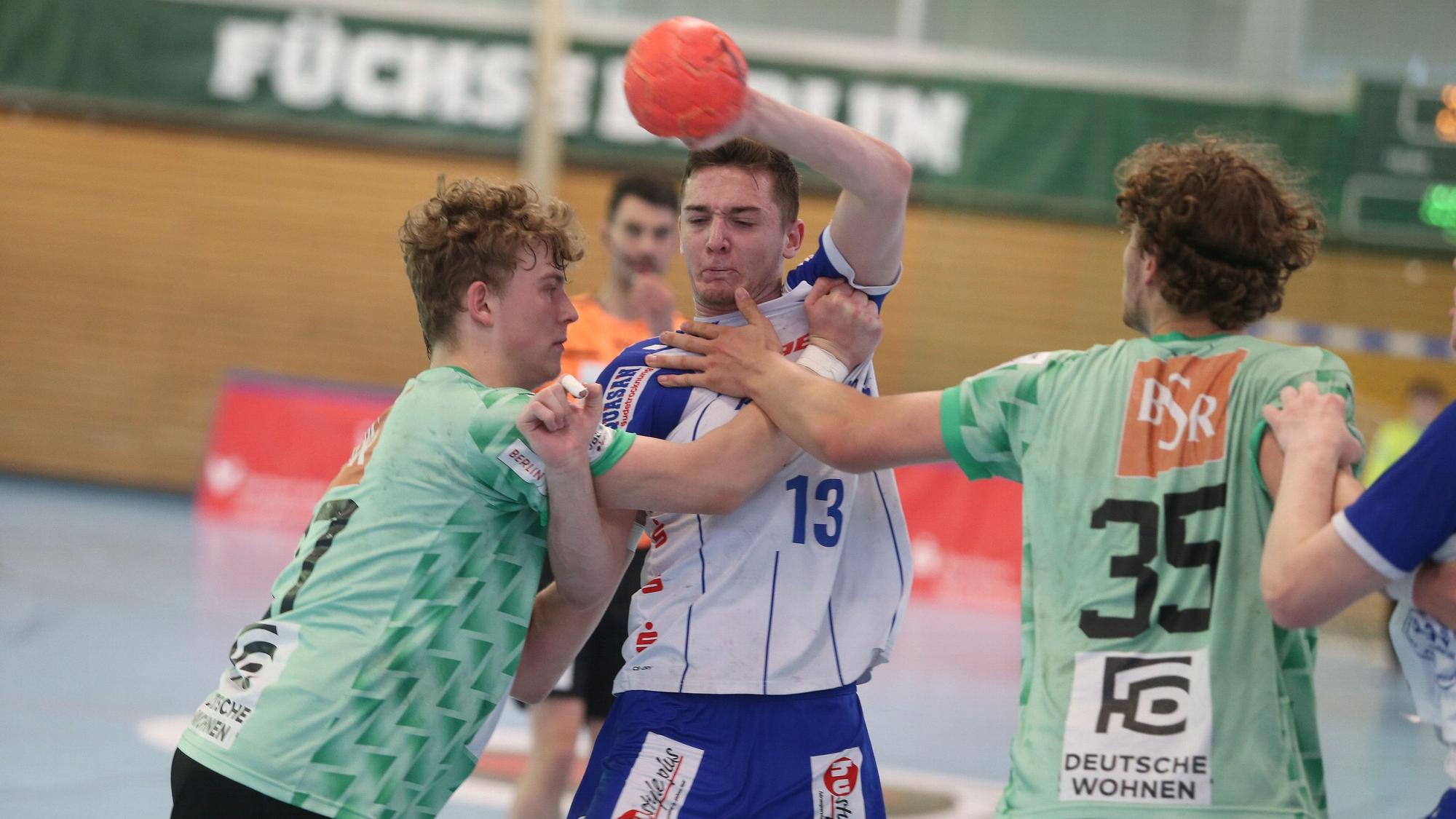 Ein Handballspieler im Angriff setzt sich gegen die Abwehr durch.