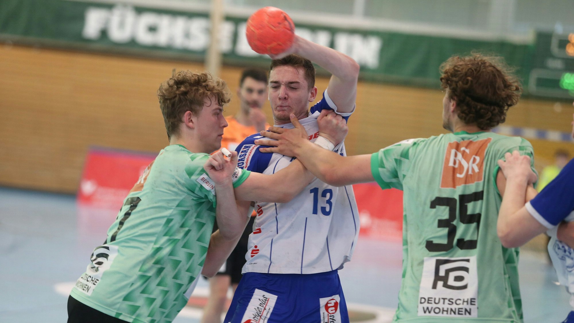 Ein Handballspieler im Angriff setzt sich gegen die Abwehr durch.