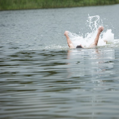 Ein Mann rudert in einem See mit seinen Armen