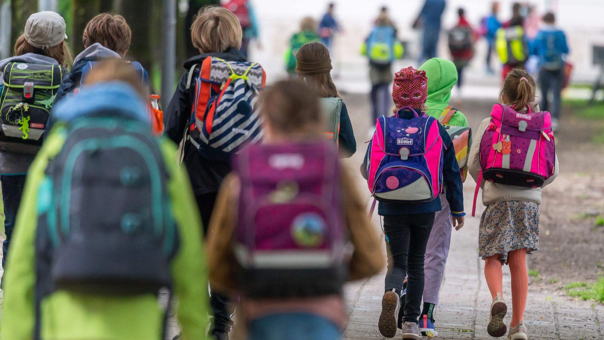 Schulkinder gehen in die Schule.