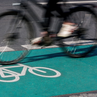 Eine Radfahrerin fährt über einen grün eingefärbten Radweg.