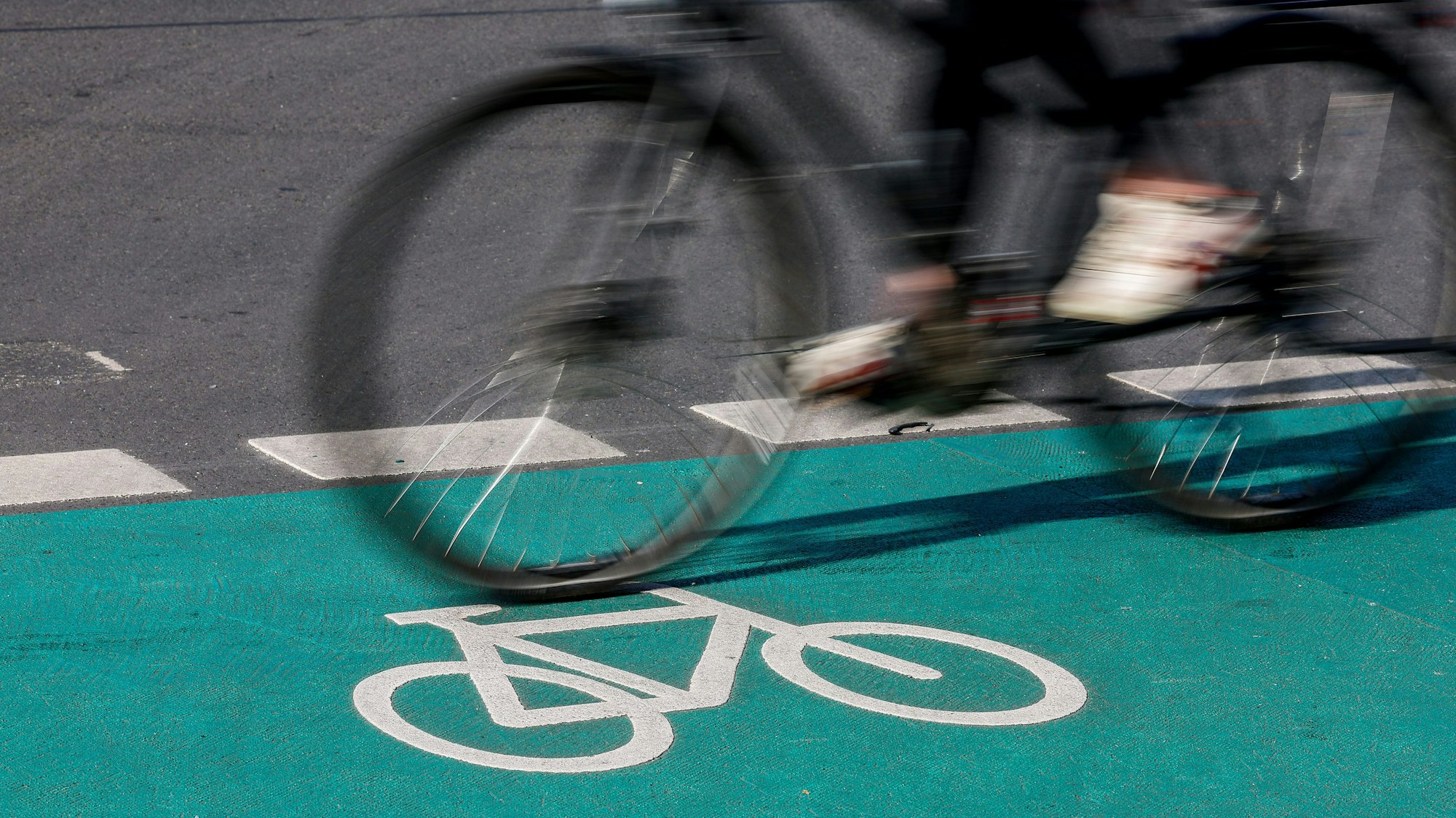 Eine Radfahrerin fährt über einen grün eingefärbten Radweg.