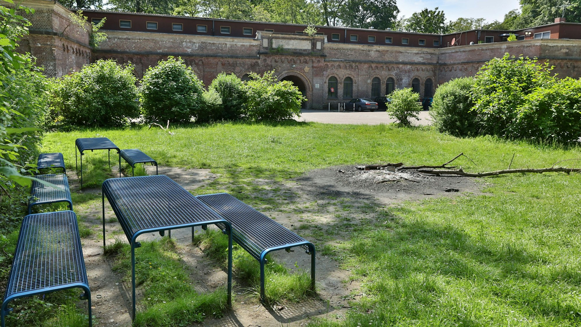 Im Vordergrund sind Bänke und Tische sowie eine Feuerstelle zu sehen, im Hintergrund das Decksteiner Fort.