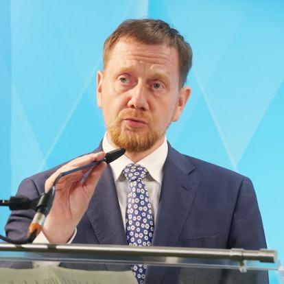 Der sächsische Ministerpräsident Michael Kretschmer (CDU) richtet bei einer Pressekonferenz sein Mikrofon.