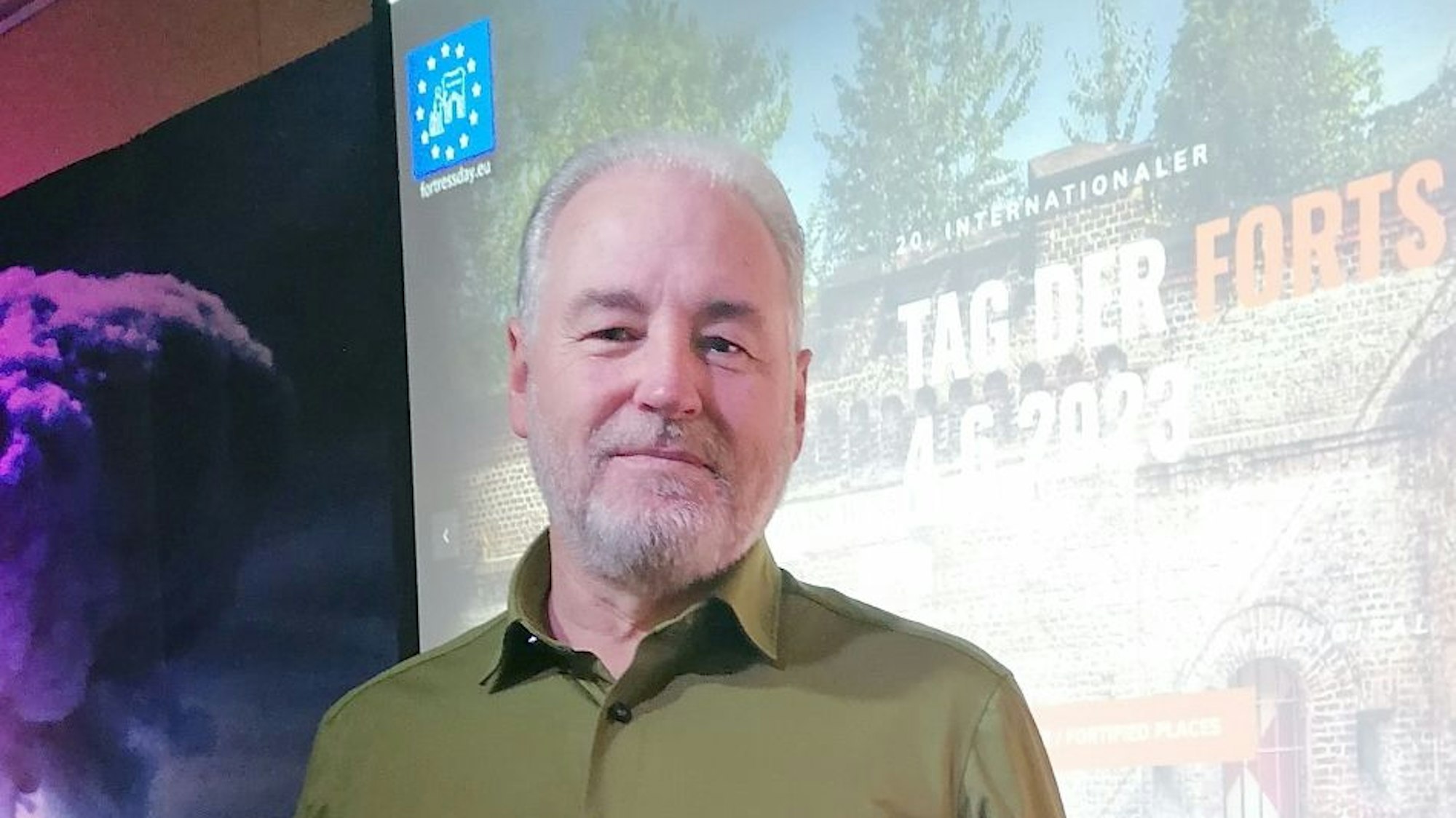 Chef-Organisator Robert Schwienbacher steht vor einer Leinwand.