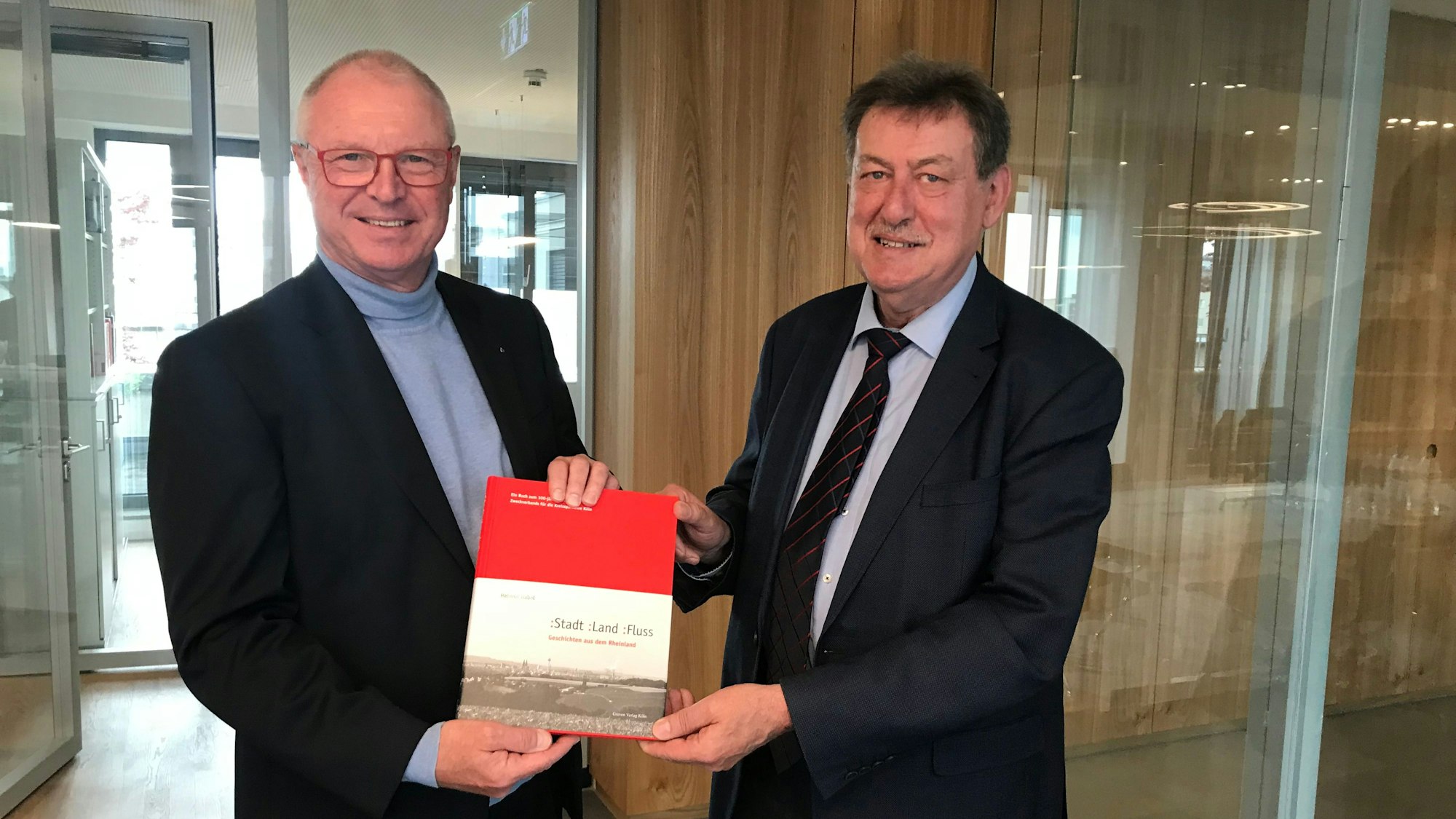 Alexander Wüerst und Helmut Gabel halten das Buch gemeinsam hoch.