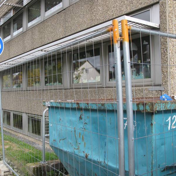 Die Kita in Hennef befindet sich hinter einem Bauzaun. Vor dem Zaun steht ein Schild, das darauf hinweist, dass hier nur Busse langfahren dürfen.