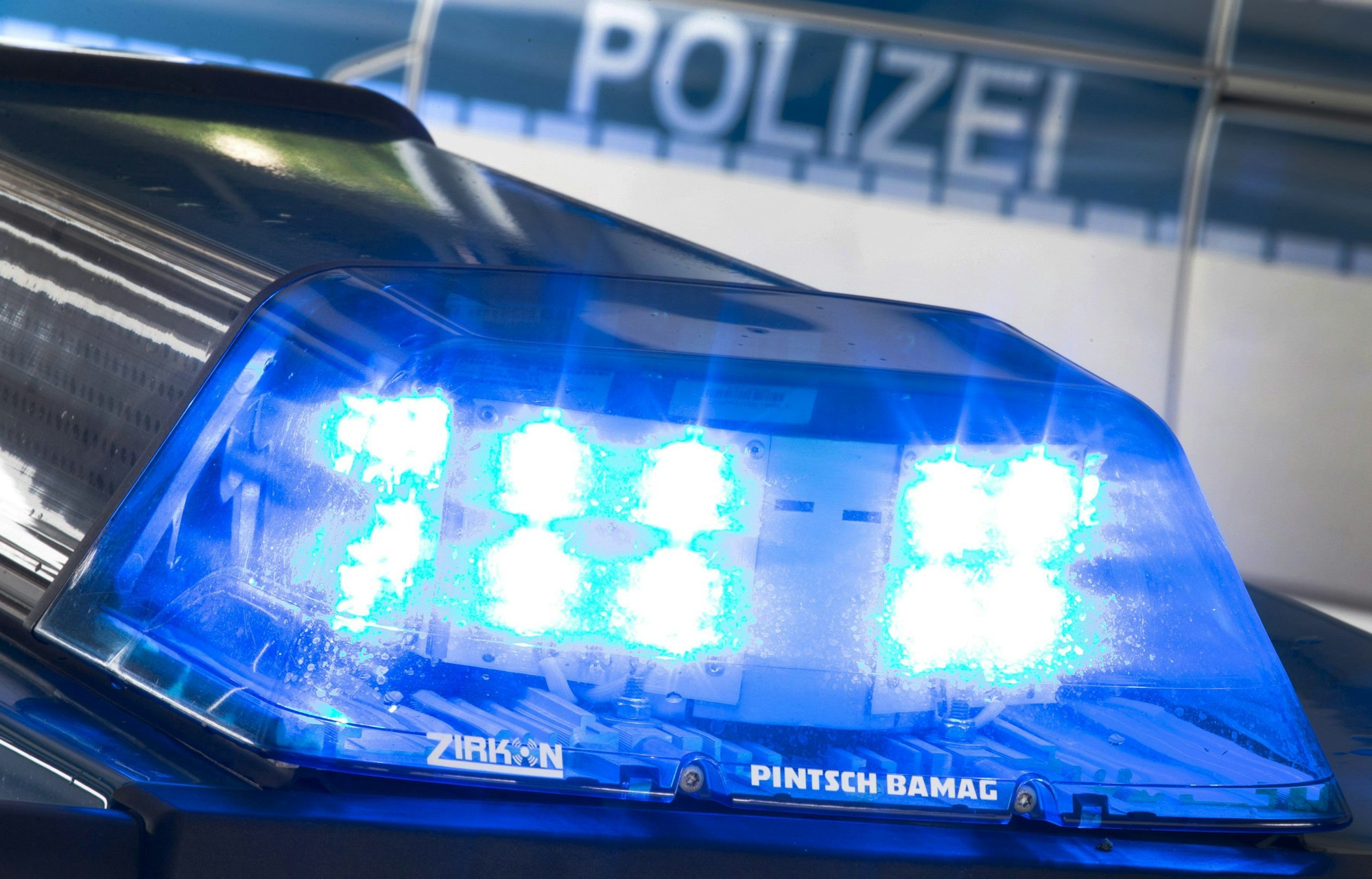 Eine Blaulicht leuchtet auf dem Dach eines Polizeiwagens.