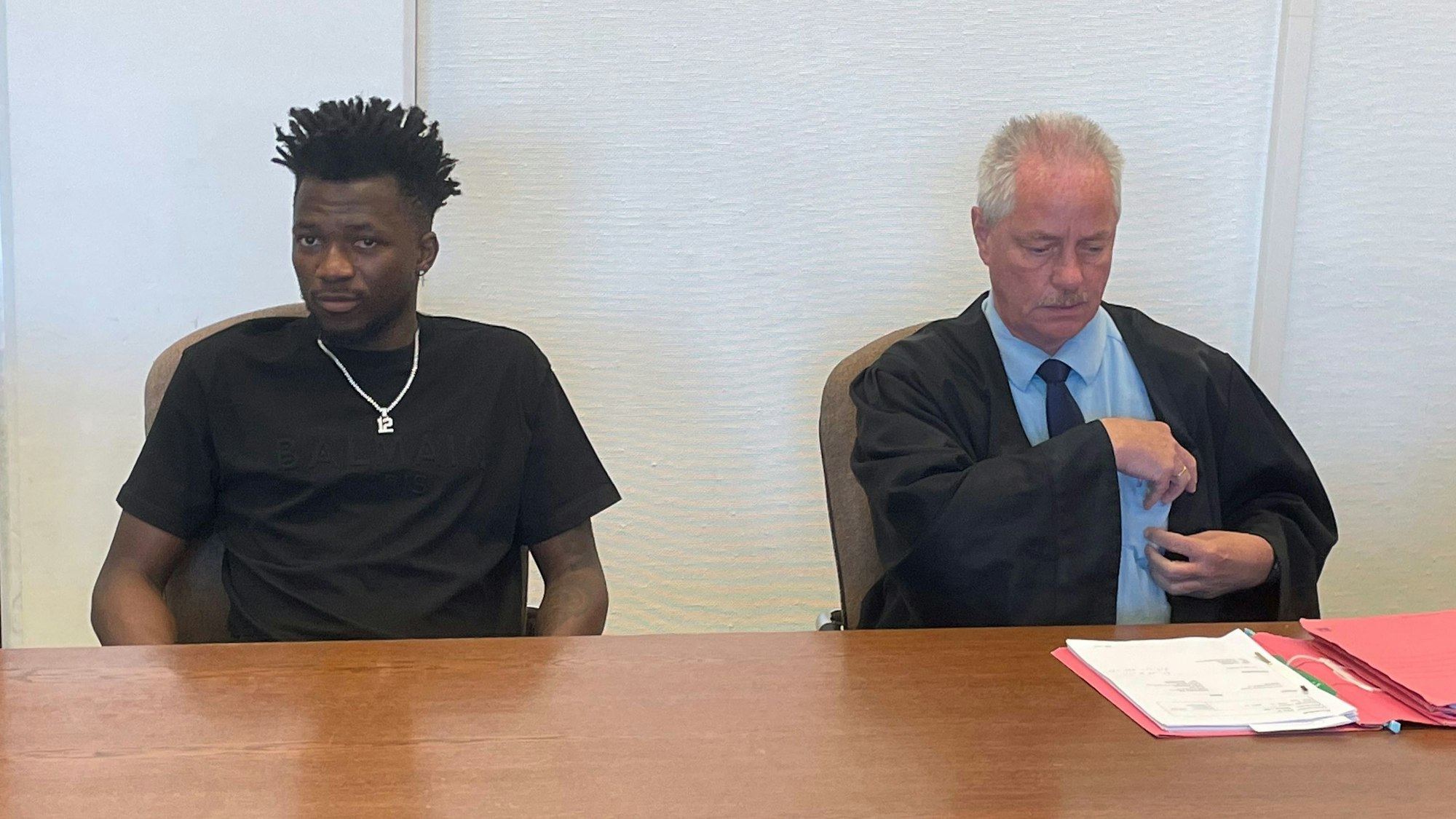 Bundesliga-Profi Edmond Tapsoba von Bayer Leverkusen im Amtsgericht Köln mit seinem Verteidiger Heinz Petersohn.