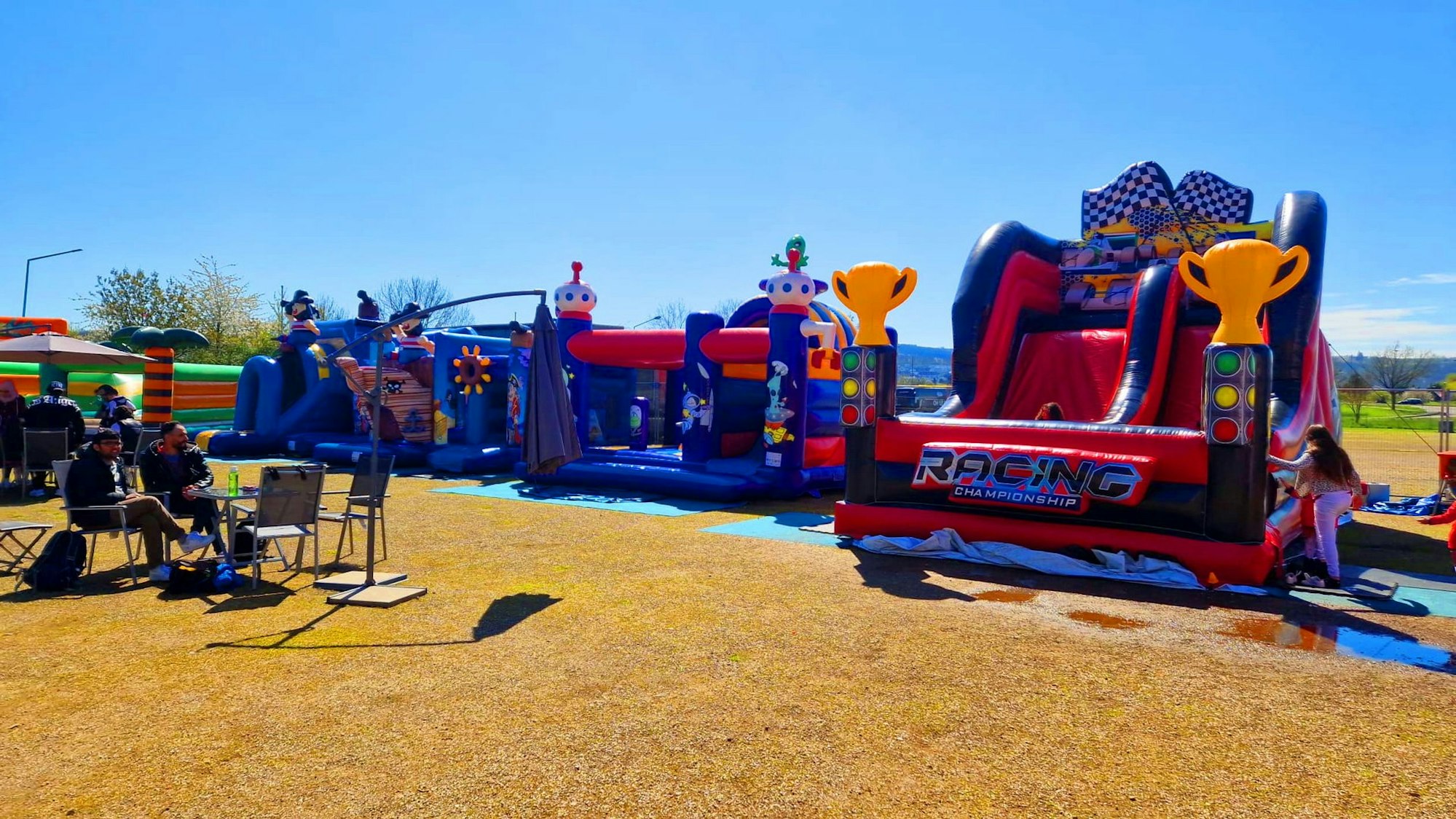 Hüpfburgen stehen auf einem Platz.