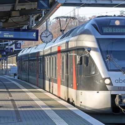Ein Zug von Abellio steht im Hauptbahnhof. Die Sonne scheint auf die silberfarbenen Wagen.