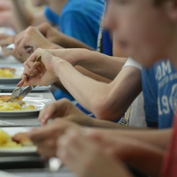 Schüler des Immanuel-Kant-Gymnasiums essen in der Mensa der Schule. 
Manche Schulen bieten in der Mensa Essen für alle Schülerinnen und Schüler an.