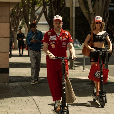 Eine Frau und ein Mann auf E-Scootern
