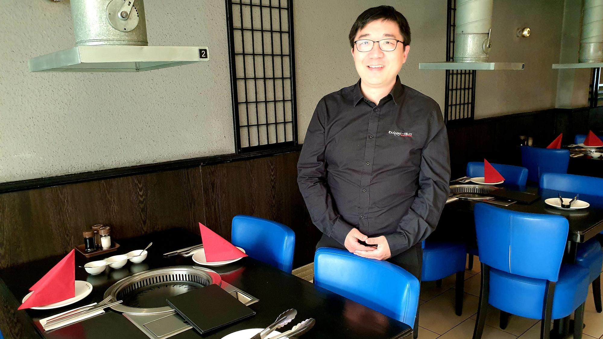 Geschäftsführer Hyun-Jae An steht zwischen den Tischen des Bulgogi-Hauses.