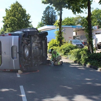 Auf der Straße liegt ein umgekippter Wagen. Feuerwehrleute kümmern sich um den Unfall.