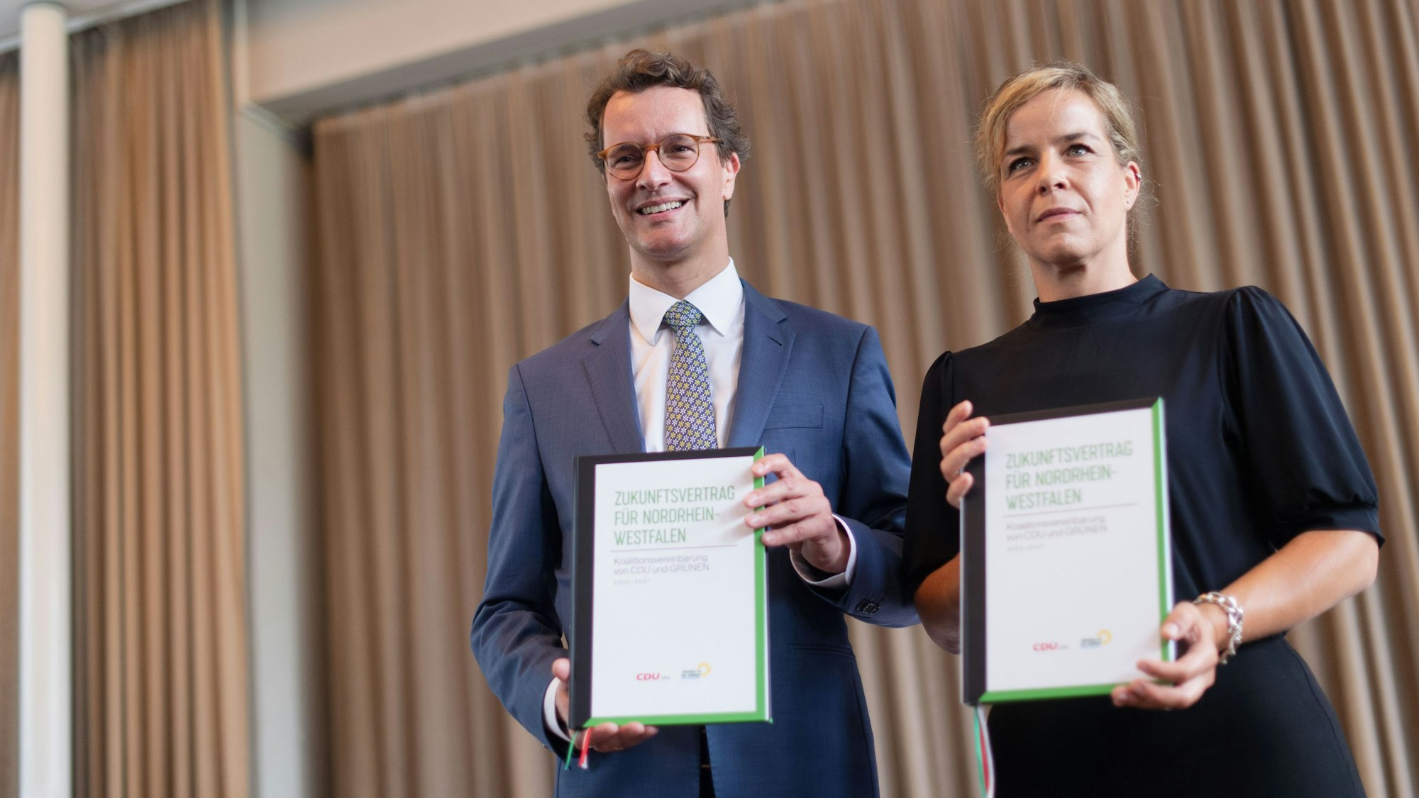 Hendrik Wüst (CDU), Ministerpräsident von Nordrhein-Westfalen, und Mona Neubaur (Bündnis 90/Die Grünen) präsentieren nach der Unterzeichnung den Koalitionsvertrag.