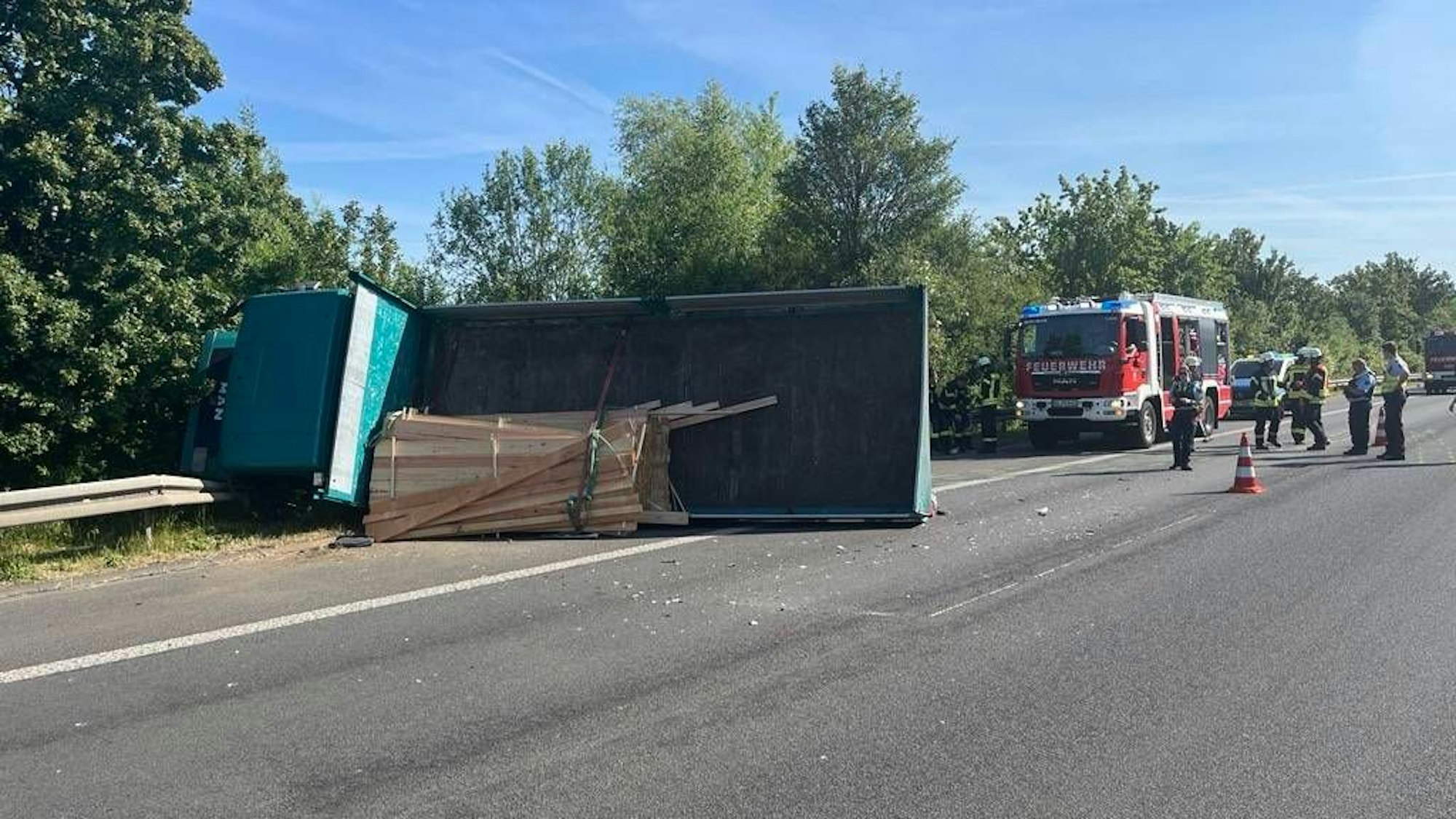Der Lkw liegt in der Leitplanke auf der Seite.