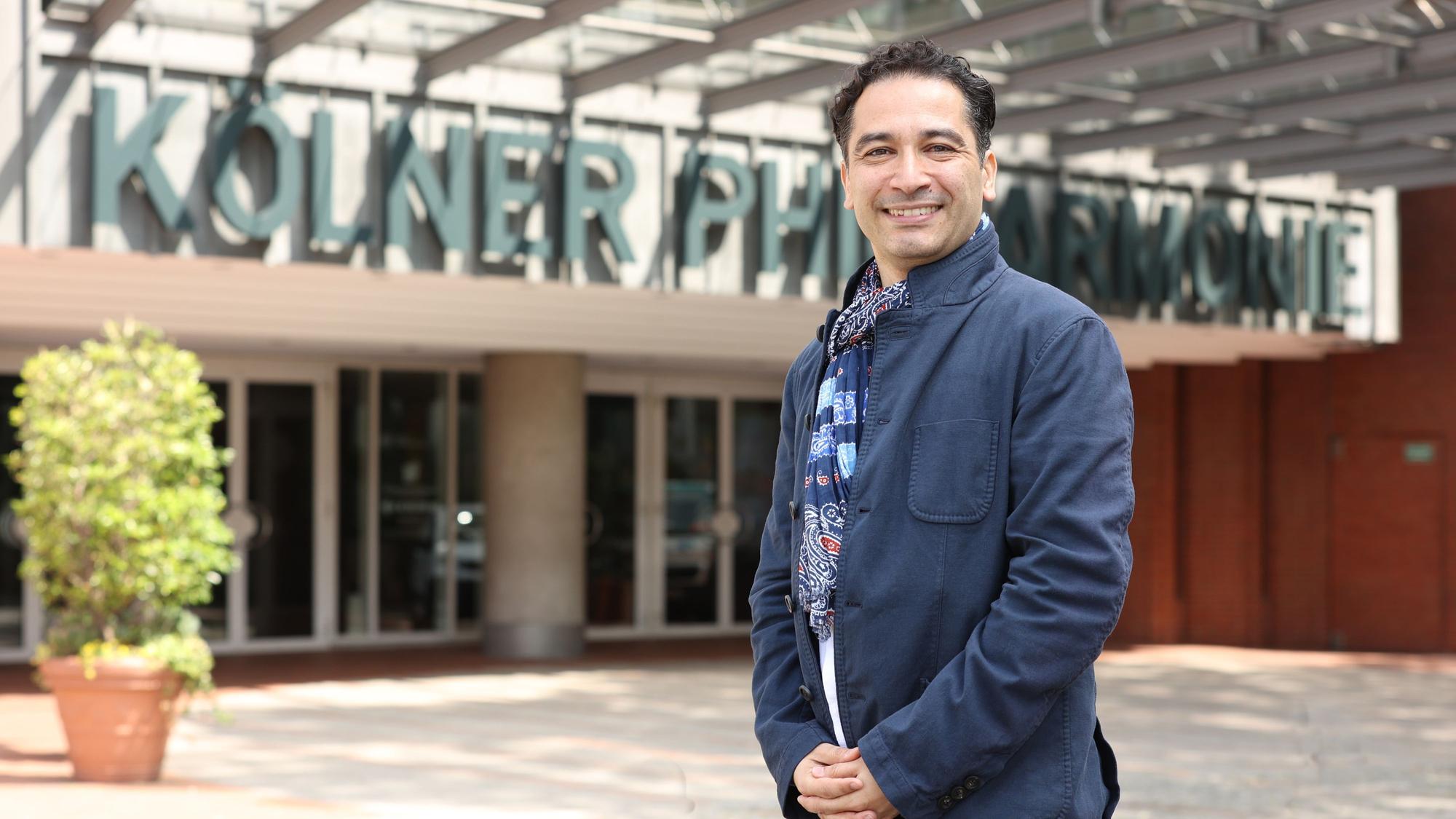 Andrés Orozco-Estrada steht vor der Kölner Philharmonie.